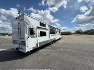 Large white fifth-wheel travel trailer in a parking lot