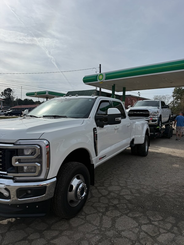 White Ford F-350 dually truck towing a trailer at a BP gas station