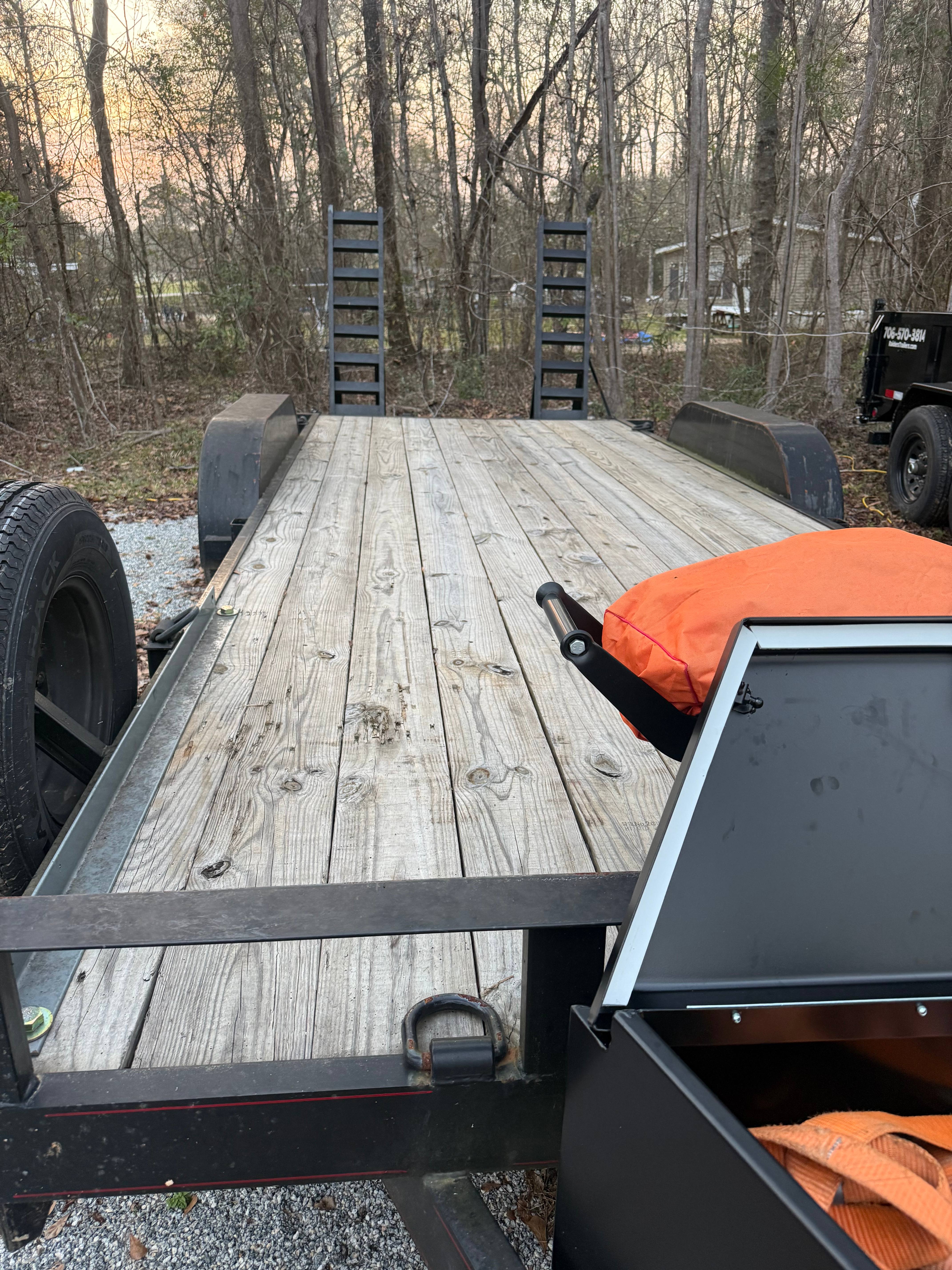 Flatbed equipment trailer hauling a vehicle