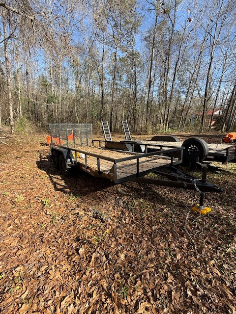 Utility trailer with mesh side rails on a dealer lot